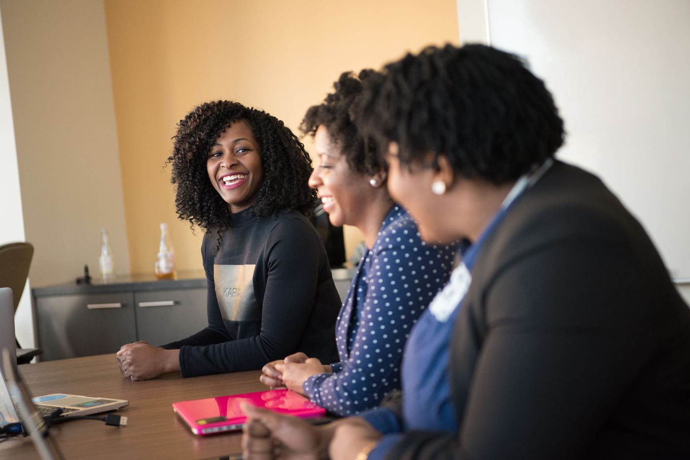 Professional women collaborating and laughing in a meeting